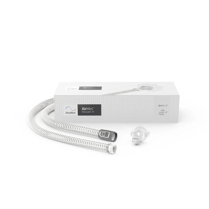 Sleep apnea device with hose and packaging on a white background